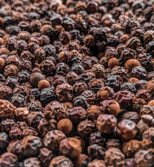 A detailed close-up shot of black peppercorns showcasing their texture and pattern.